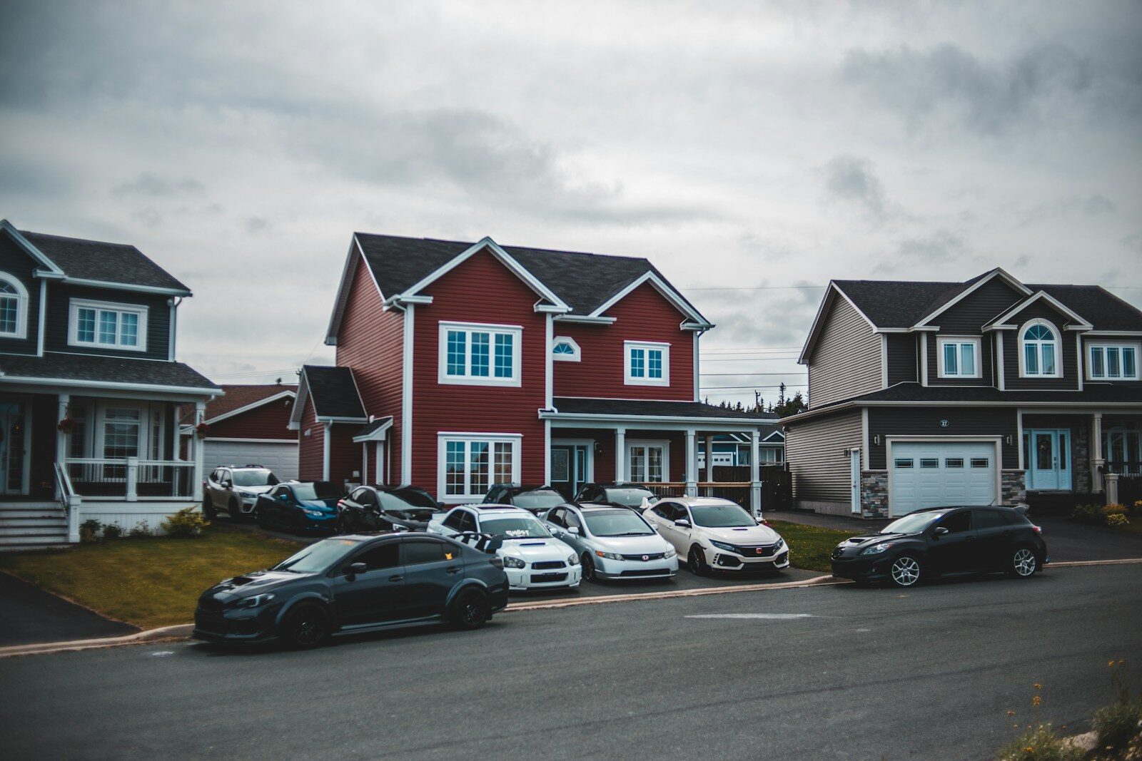 cars parked in front of houses during daytime